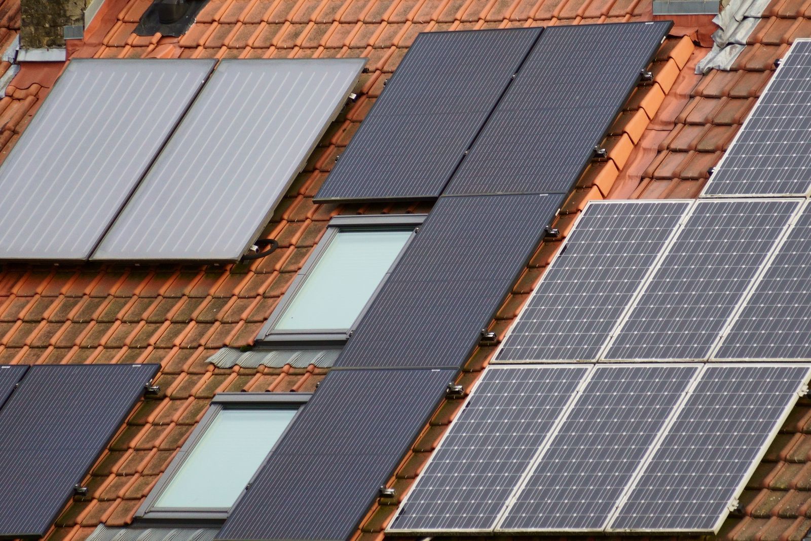Panneaux solaires et fenêtres de toit sur une couverture en tuiles